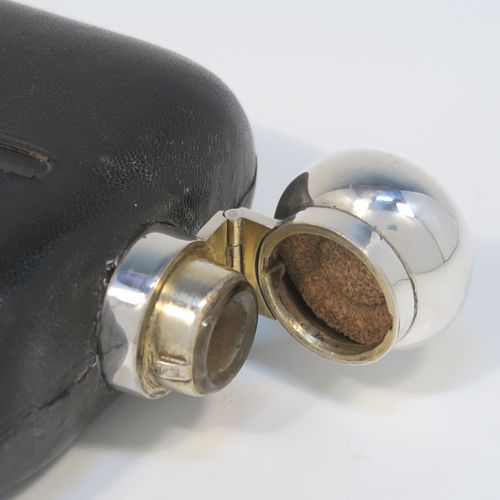 A large and handsome Antique Sterling Silver and glass whisky flask, with dark leather skin mount, and a sight level both sides, having a bayonet fit lid and a pull-off cup with gold-gilt interior. This elegant silver and glass hip flask was made by James Dixon and Sons of Sheffield in 1919. The dimensions of this fine hand-made silver and glass whisky flask are length 19 cms (7.5 inches), width 12 cms (4.75 inches), and depth 4.5 cms (1.75 inches).