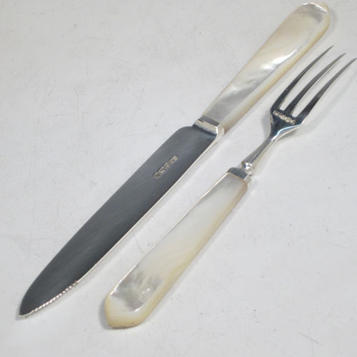 Antique Edwardian sterling silver and mother-of-pearl handled fruit set for twelve people. Having tapering bladed knives with serrated points and three-prong forks, all fitted into an original presentation box with dark green velvet interior. Made by Henry Atkins of Sheffield in 1910. The dimensions of this fine hand-made silver fruit service are length of knife 18 cms (7 inches), and the length of the fork 14.5 cms (5.75 inches). Please note that the brass plaque on top of the box lid is monogrammed.