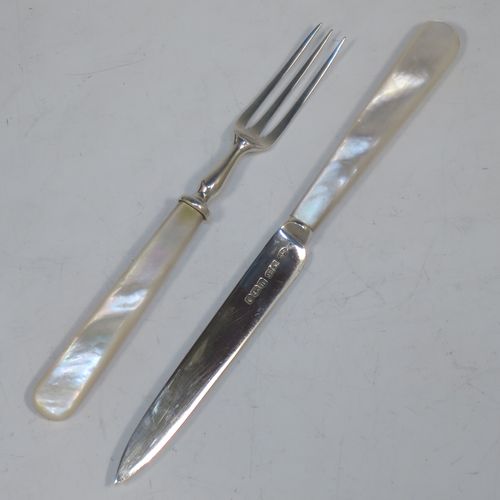 A very elegant Antique Sterling Silver and mother-of-pearl handled fruit set for twelve people. Having plain straight-sided pointed-end blade knives, and three-prong forks. All fitted into an original presentation box with cream satin and dark blue velvet interior. Made by James Dixon and Sons of Sheffield in 1925. The dimensions of this fine hand-made antique silver fruit service are length of knife 19 cms (7.5 inches), and the length of the fork 13.5 cms (5.25 inches).