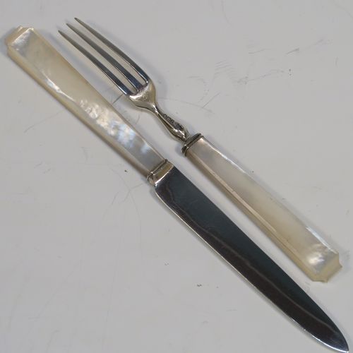 A very elegant Art Deco style Sterling Silver and mother-of-pearl handled fruit set for six people. Having plain straight-sided pointed-end blade knives, and three-prong forks. All fitted into an original wooden presentation box with black velvet-lined interior. This handsome silver fruit set was made by James Dixon and Sons of Sheffield in 1934. The dimensions of this fine hand-made silver and mother-of-pearl fruit service are length of knife 17 cms (6.75 inches), and the length of the fork 13.5 cms (5.3 inches).