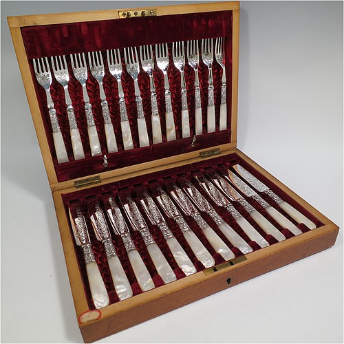 An Antique Victorian silver-plated and mother-of-pearl handled fruit set for twelve people, having hand-engraved tapering bladed knives and four-prong forks with floral decoration, with large hand-chased silver ferrules connecting the mother-of-pearl handles, all fitted into their original maroon satin and velvet-lined presentation box. The ferrules are of hallmarked sterling silver and are made by John Sanderson of Sheffield in 1897. The dimensions of this fine hand-made antique silver fruit service are length of knife 21 cms (8.25 inches), and the length of the fork 17.5 cms (7 inches).   