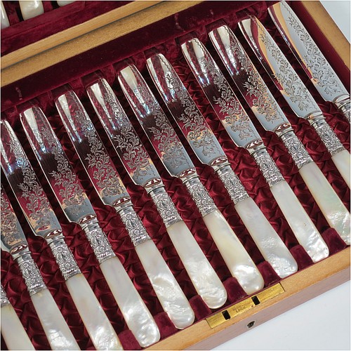 An Antique Victorian silver-plated and mother-of-pearl handled fruit set for twelve people, having hand-engraved tapering bladed knives and four-prong forks with floral decoration, with large hand-chased silver ferrules connecting the mother-of-pearl handles, all fitted into their original maroon satin and velvet-lined presentation box. The ferrules are of hallmarked sterling silver and are made by John Sanderson of Sheffield in 1897. The dimensions of this fine hand-made antique silver fruit service are length of knife 21 cms (8.25 inches), and the length of the fork 17.5 cms (7 inches).