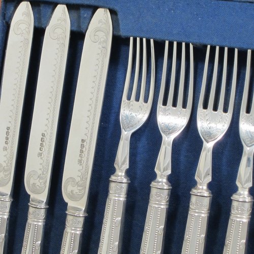 Antique Victorian sterling silver fruit set for twelve people, having hand-engraved floral decoration on the blades and four-prong forks, and the handles in a very pretty pattern with reeding and bead-work, all fitted into an original wooden presentation box with dark blue velvet interior. Made by Thomas Bradbury and Sons of Sheffield in 1883. The dimensions of this fine hand-made silver fruit service are length of knife 21.5 cms (8.5 inches), and the length of the fork 18.5 cms (7.25 inches).