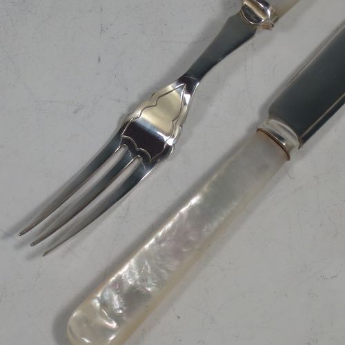 An Antique Edwardian Silver-plated and mother-of-pearl handled fruit set for twelve people. Having straight-sided pointed-end blade knives, and three-prong forks, with hand-engraved reed and diamond decoration, all fitted into an original oak wood presentation box with black velvet-lined interior. Made by Rattray and Co., of Dundee, Scotland, in ca. 1910. The dimensions of this fine hand-made antique silver-plated fruit service are length of knife 16.5 cms (6.5 inches), and the length of the fork 14.5 cms (5.75 inches).