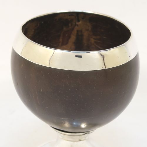 An elegant Antique Georgian Sterling Silver Coconut mounted goblet, with an applied vacant cartouche on one side, a plain round top border, and sitting on a plain round pedestal foot. This handsome antique silver and coconut goblet was made by Charles and David Reid of Newcastle in 1829. The dimensions of this fine hand-made silver and coconut goblet are height 11.5 cms (4.5 inches), and diameter of main body 9.5 cms (3.75 inches).