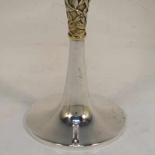 A very elegant Sterling Silver champagne flute goblet, having a plain round tapering body, and sitting on a plain round pedestal foot, with an applied central gold-gilt and florally decorated stem. This beautiful silver champagne goblet flute was made by Peter Nicholas and Co. Ltd., of London in 1987. The dimensions of this fine hand-made silver champagne flute are height 21 cms (8.25 inches), diameter at lip 5.5 cms (2.25 inches), and it weighs approx. 175g (5.6 troy ounces).