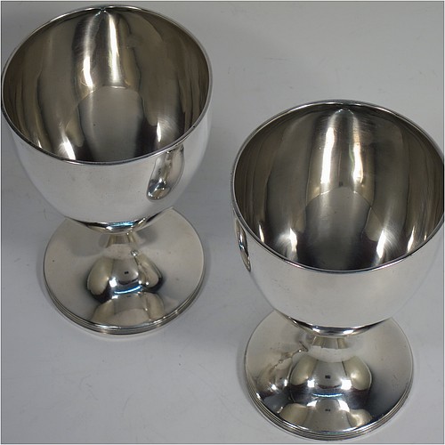 A very handsome pair of Antique Georgian Sterling Silver goblets, having plain round bodies with tapering sides, and sitting on pedestal feet with reeded borders. Made by John Robins of London in 1800. The dimensions of this fine hand-made pair of antique silver goblets are height 12 cms (4.75 inches), diameter at top 8 cms (3 inches), and the total weight is approx. 384g (12.4 troy ounces).