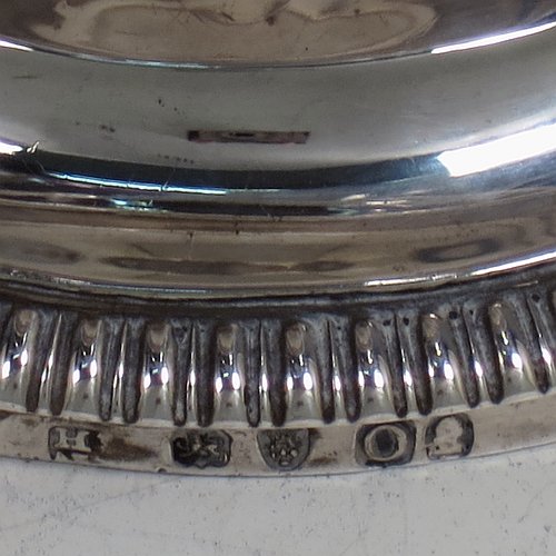 An Antique Georgian Sterling Silver wine goblet, having a plain round tapering body with straight sides, an applied reeded top border, and sitting on a pedestal foot with an applied straight gadroon edge. Made by Henry Nutting & Robert Hennell of London in 1809. The dimensions of this fine hand-made antique silver goblet are height 15 cms (6 inches), diameter at lip 9 cms (3.5 inches), and it weighs approx. 252g (8 troy ounces).