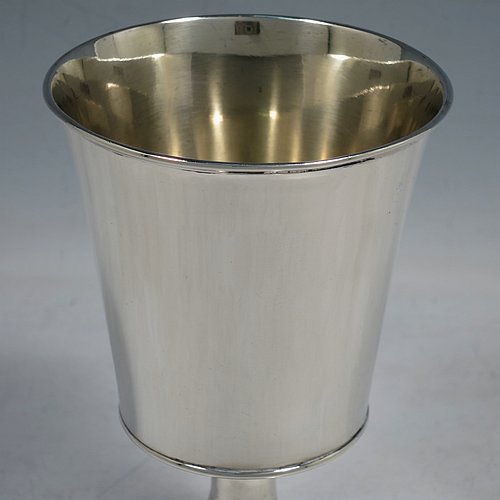 An Antique Georgian Sterling Silver wine goblet, having a plain round tapering body with straight sides, an applied reeded top border, and sitting on a pedestal foot with an applied straight gadroon edge. Made by Henry Nutting & Robert Hennell of London in 1809. The dimensions of this fine hand-made antique silver goblet are height 15 cms (6 inches), diameter at lip 9 cms (3.5 inches), and it weighs approx. 252g (8 troy ounces).