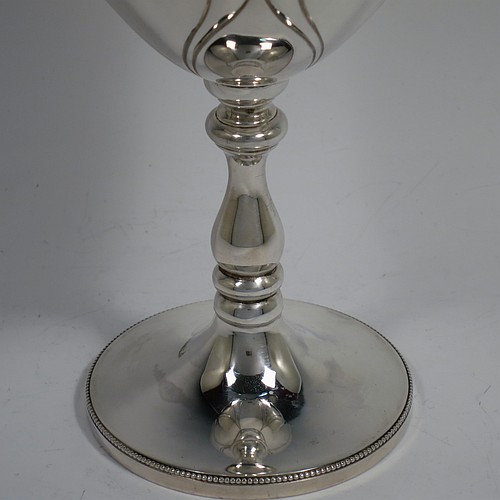 A large Antique Edwardian Sterling Silver Art Nouveau style goblet, having a round tapering body with hand-chased anthemion leaf work and plain tear-drop shaped cartouches, sitting on a pedestal foot with a bead border, and with a gold-gilt interior. Made by the Cooper Brothers of Sheffield in 1904. The dimensions of this fine hand-made antique silver Art Nouveau goblet are height 20 cms (8 inches), diameter at lip 10 cms (4 inches), and it weighs approx. 285g (9.2 troy ounces).