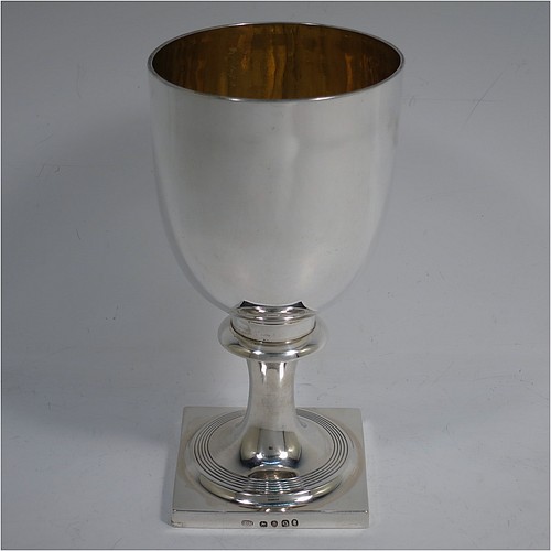 A very handsome Antique Georgian Sterling Silver heavy goblet, having a plain round tapering body with a gold-gilt interior, and sitting on a pedestal foot with reeded decoration and a square base. Made by Thomas Hobbs of London in 1811. The dimensions of this fine hand-made antique silver goblet are height 17 cms (6.75 inches), diameter at lip 9 cms (3.5 inches), and it weighs approx. 312g (10 troy ounces).    