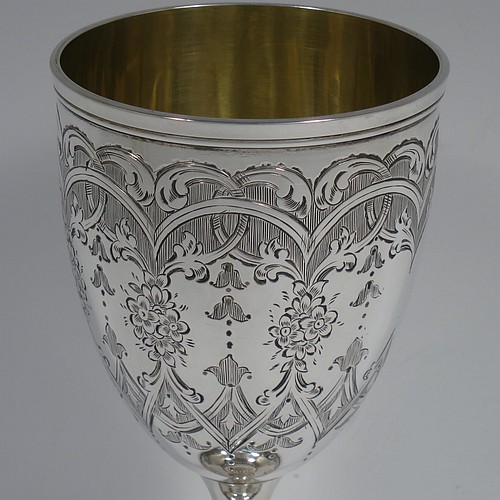 A very pretty Antique Victorian Sterling Silver goblet, having a round bellied body with hand-engraved floral and scroll decoration, with a vacant cartouche on one side, a gold-gilt interior, and sitting on a pedestal foot with hand-engraved decoration and applied bead-edged borders. Made by Henry Wilkinson of London in 1868. The dimensions of this fine hand-made antique silver goblet are height 16.5 cms (6.5 inches), diameter at lip 7.5 cms (3 inches), and it weighs approx. 148g (4.8 troy ounces).