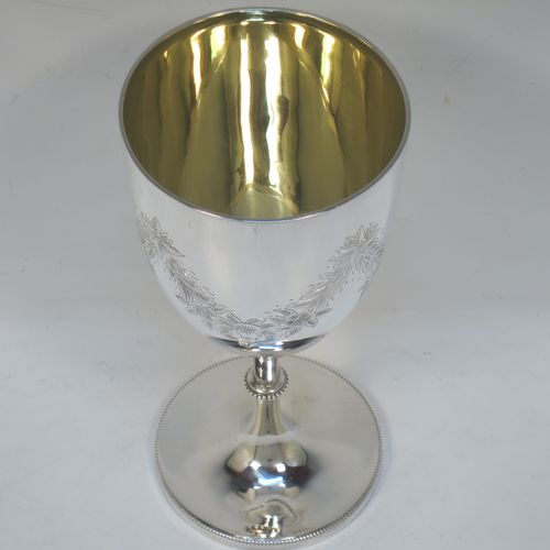A very pretty Antique Victorian Sterling Silver goblet, having a round bellied body with hand-engraved swags of floral decoration, a gold-gilt interior, and sitting on a pedestal foot with an applied bead-edged border. Made by James Dixon and Sons of Sheffield in 1877. The dimensions of this fine hand-made antique silver goblet are height 18 cms (7 inches), diameter at lip 8.5 cms (3.3 inches), and it weighs approx. 224g (7.2 troy ounces).