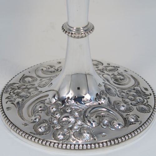 A large and beautiful Antique Victorian sterling silver goblet, having a round body with tapering sides and a gold-gilt interior, all hand-chased with floral and scroll decoration surrounding two vacant cartouches, and sitting on a pedestal foot with matching decoration and applied bead-edged borders. This large and impressive antique silver goblet was made by the Atkin Brothers of Sheffield in 1893. The dimensions of this fine hand-made silver goblet are height 25.5 cms (10 inches), diameter at lip 11.5 cms (4.5 inches), and it weighs approx. 472g (15.2 troy ounces).   