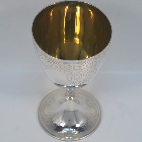 A very pretty Antique Victorian Sterling Silver goblet, having a round body with tapering sides and hand-engraved floral and scroll decoration, a gold-gilt interior, and sitting on a pedestal foot with hand-engraved decoration and an applied bead-edged border. This beautiful silver goblet was made by Joseph Rogers of Sheffield in 1875. The dimensions of this fine hand-made antique silver goblet are height 17 cms (6.6 inches), diameter at lip 9 cms (3.5 inches), and it weighs approx. 211g (6.8 troy ounces).  