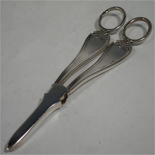 A very handsome and heavy Sterling Silver pair of grape shears or scissors in a double struck pattern with reeded borders and shell and scroll terminals. Made by Charles Boyton and Sons of Sheffield in 1931. The dimensions of this fine hand-made pair of silver grape scissors or shears are length 18 cms (7 inches), and they weigh approx. 123g (4 troy ounces).
