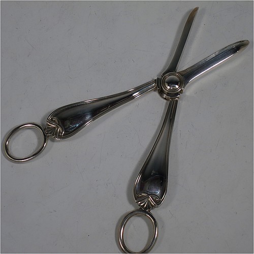 A very handsome and heavy Sterling Silver pair of grape shears or scissors in a double struck pattern with reeded borders and shell and scroll terminals. Made by Charles Boyton and Sons of Sheffield in 1931. The dimensions of this fine hand-made pair of silver grape scissors or shears are length 18 cms (7 inches), and they weigh approx. 123g (4 troy ounces).