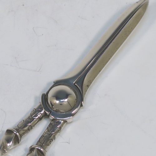A very pretty Antique Victorian Sterling Silver pair of grape shears or scissors, with cast handles in a twisted style, with plain loop handles and hand-chased terminals, all in its original maroon velvet and stain-lined presentation box. This beautiful pair of antique silver grape scissors were made by Edward Hutton of London in 1889. The dimensions of this fine hand-made pair of antique silver grape shears are length 17.5 cms (7 inches), and they weigh approx. 109g (3.5 troy ounces).
