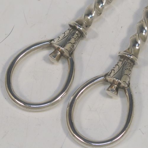 A very pretty Antique Victorian Sterling Silver pair of grape shears or scissors, with cast handles in a twisted style, with plain loop handles and hand-chased terminals, all in its original maroon velvet and stain-lined presentation box. This beautiful pair of antique silver grape scissors were made by Edward Hutton of London in 1889. The dimensions of this fine hand-made pair of antique silver grape shears are length 17.5 cms (7 inches), and they weigh approx. 109g (3.5 troy ounces).