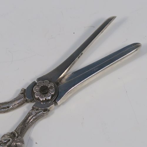 A very pretty and heavy Antique Victorian Sterling Silver pair of grape shears or scissors, having cast grapevine style handles. This beautiful silver pair of grape shears were made by Henry John Lias of London in 1864. The dimensions of this fine hand-made pair of antique silver grape scissors are length 19 cms (7.5 inches), and they weigh approx. 155g (5 troy ounces).   