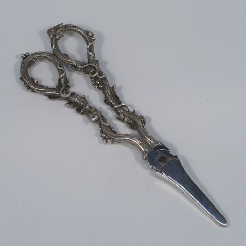 A very pretty and heavy Antique Victorian Sterling Silver pair of grape shears or scissors, having cast grapevine style handles. This beautiful silver pair of grape shears were made by Henry John Lias of London in 1864. The dimensions of this fine hand-made pair of antique silver grape scissors are length 19 cms (7.5 inches), and they weigh approx. 155g (5 troy ounces).   