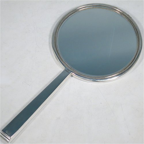 A Sterling Silver hand-mirror, having a round body and a square cross-section handle, with engine-turned decoration and a very pretty hand-engraved floral border, and an original round bevelled mirror. Made by Broadway & Co., of Birmingham in 1971. The dimensions of this fine hand-made silver hand mirror are length 25.5 cms (10 inches), and diameter of mirror 12.5 cms (5 inches).
