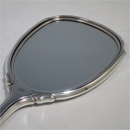 A very pretty Sterling Silver hand-mirror, having a shaped rectangular body with reeded borders, a hand-engraved back with floral decoration, and an original bevelled mirror. Made by Deakin and Francis of Birmingham in 1966. The dimensions of this fine hand-made silver hand mirror are length 26 cms (10.25 inches), and width 10 cms (4 inches).
