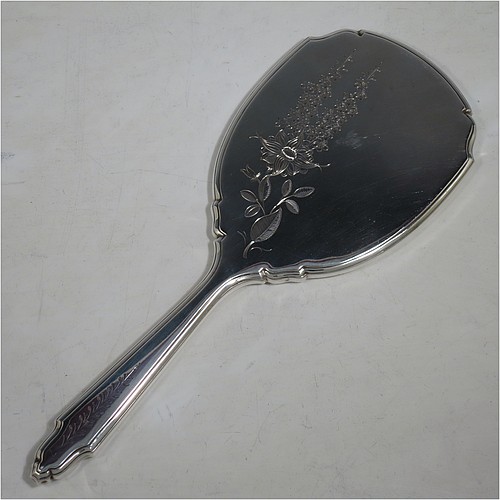 A very pretty Sterling Silver hand-mirror, having a shaped rectangular body with reeded borders, a hand-engraved back with floral decoration, and an original bevelled mirror. Made by Deakin and Francis of Birmingham in 1966. The dimensions of this fine hand-made silver hand mirror are length 26 cms (10.25 inches), and width 10 cms (4 inches).