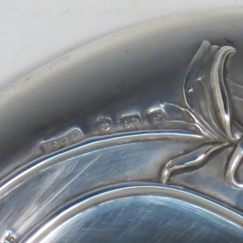 An Antique Edwardian Art Nouveau Sterling Silver hand-mirror, having a round body with hand-chased floral lilly decoration, and an original round bevelled mirror with rope-twist border. Made by Henry Williamson Ltd., of Birmingham in 1905. The dimensions of this fine hand-made antique silver hand mirror are length 28 cms (11 inches), and diameter 15 cms (6 inches). Please note that the mirror glass has very slight scratches concurrent with its age.