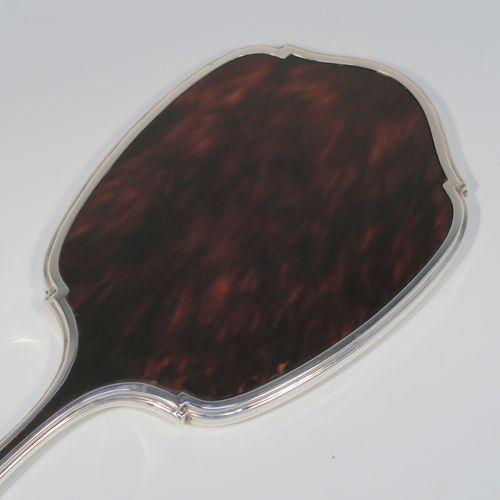 An elegant Sterling Silver and Tortoise-shell hand-mirror, having a shaped rectangular body, with original tortoiseshell back, and an original bevelled mirror. This handsome silver hand mirror was made by the Adie Brothers of Birmingham in 1930. The dimensions of this fine hand-made silver and tortoise-shell hand mirror are length 31 cms (12.25 inches), and width 11.5 cms (4.5 inches).   