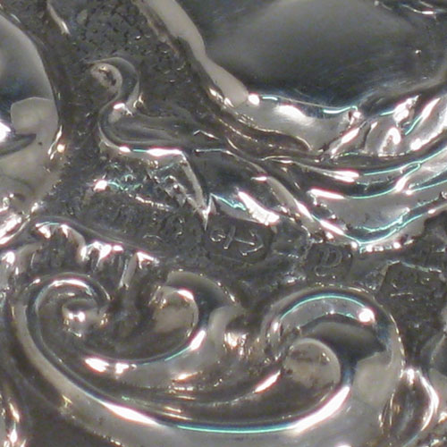 Antique Victorian sterling silver hand-mirror, having an oval body with hand-chased floral decoration and cherub, a central vacant cartouche, and an oval bevelled mirror with rope-twist border. Made by Henry Hayes of Birmingham in 1898. The dimensions of this fine hand-made silver hand mirror are length 26 cms (10 inches), and width 10 cms (4 inches). Please note that the mirror surface shows signs of very slight clouding.