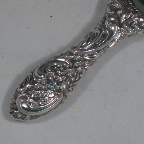 Antique Victorian sterling silver hand-mirror, having an oval body with hand-chased floral decoration and cherub, a central vacant cartouche, and an oval bevelled mirror with rope-twist border. Made by Henry Hayes of Birmingham in 1898. The dimensions of this fine hand-made silver hand mirror are length 26 cms (10 inches), and width 10 cms (4 inches). Please note that the mirror surface shows signs of very slight clouding.