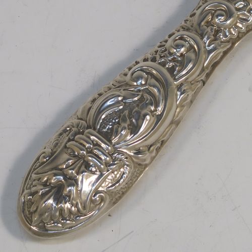 A very pretty Sterling Silver hand-mirror, having a round body with hand-chased floral and scroll decoration surrounding a central vacant cartouche, and a round bevelled mirror with rope-twist border. This beautiful silver hand mirror was made in Birmingham in 1982. The dimensions of this fine hand-made silver hand mirror are length 23.5 cms (9.25 inches), and diameter of main body 12.5 cms (5 inches).