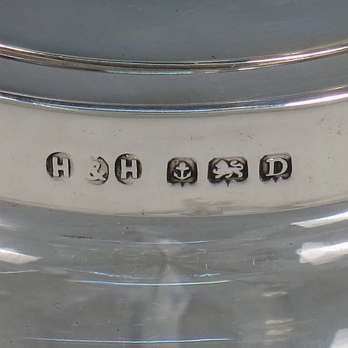 A Sterling Silver and crystal honey or jam jar, having a round bellied body with hand-cut geometrical design and a star-cut base, a plain round mount, with a mechanical swing-handled hinged and domed lid. Made by Hukin & Heath of Birminghamn in 1928. The dimensions of this fine hand-made silver and glass conserve jar are height (inc. handle) 12.5 cms (5 inches), and diameter 11 cms (4.3 inches).