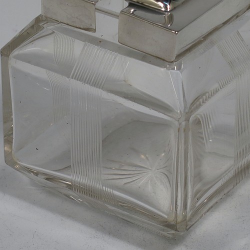 A very pretty Antique Edwardian sterling silver and hand-cut crystal jam, honey, or preserve jar, having a square body decorated with hand-engraved reeded vertical bands, and with sloping upper and lower borders, together with a square stepped pull-off silver lid with looped handle, and all sitting on a star-cut base. Made by Heath & Middleton of Birmingham in 1908. The dimensions of this fine hand-made antique silver and crystal jam or honey jar are height 9.5 cms (3.75 inches), and 7 cms (2.75 inches) square.