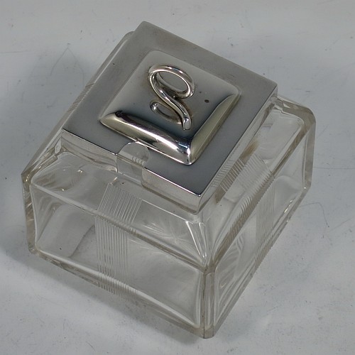 A very pretty Antique Edwardian sterling silver and hand-cut crystal jam, honey, or preserve jar, having a square body decorated with hand-engraved reeded vertical bands, and with sloping upper and lower borders, together with a square stepped pull-off silver lid with looped handle, and all sitting on a star-cut base. Made by Heath & Middleton of Birmingham in 1908. The dimensions of this fine hand-made antique silver and crystal jam or honey jar are height 9.5 cms (3.75 inches), and 7 cms (2.75 inches) square.