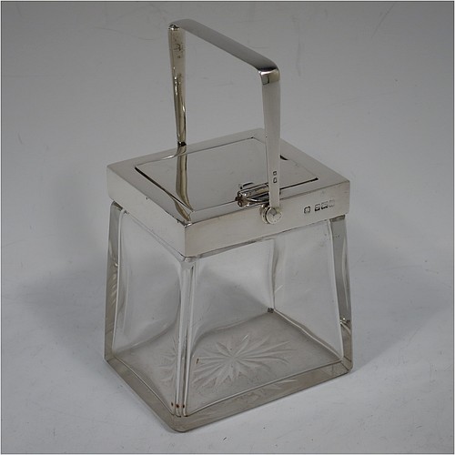 A very handsome Arts and Crafts style Antique Edwardian Sterling Silver and crystal honey, jam, or conserve jar, having a plain rectangular body with tapering sides and star-cut base, a plain rectangular mount, with a mechanical swing-handled hinged lid and a slot for a conserve  spoon. Made by Heath and Middleton of Birmingham in 1906. The dimensions of this fine hand-made Arts and Crafts silver and crystal conserve, jam, or honey jar are height (inc. handle) 14.5 cms (5.25 inches), width 9 cms (3.5 inches), and depth 6.5 cms (2.5 inches).    