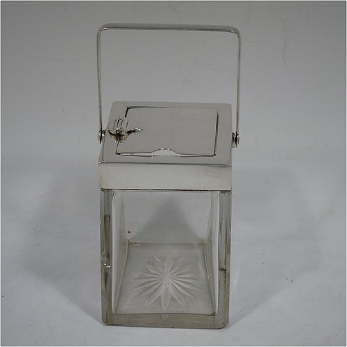A very handsome Arts and Crafts style Antique Edwardian Sterling Silver and crystal honey, jam, or conserve jar, having a plain rectangular body with tapering sides and star-cut base, a plain rectangular mount, with a mechanical swing-handled hinged lid and a slot for a conserve spoon. Made by Heath and Middleton of Birmingham in 1906. The dimensions of this fine hand-made Arts and Crafts silver and crystal conserve, jam, or honey jar are height (inc. handle) 14.5 cms (5.25 inches), width 9 cms (3.5 inches), and depth 6.5 cms (2.5 inches).