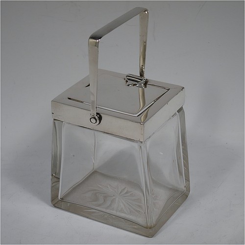 A very handsome Arts and Crafts style Antique Edwardian Sterling Silver and crystal honey, jam, or conserve jar, having a plain rectangular body with tapering sides and star-cut base, a plain rectangular mount, with a mechanical swing-handled hinged lid and a slot for a conserve spoon. Made by Heath and Middleton of Birmingham in 1906. The dimensions of this fine hand-made Arts and Crafts silver and crystal conserve, jam, or honey jar are height (inc. handle) 14.5 cms (5.25 inches), width 9 cms (3.5 inches), and depth 6.5 cms (2.5 inches).