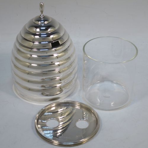 A very unusual Sterling Silver and crystal honey, jam, or conserve jar, in the shape of a bee-hive with a lift off lid, and having a plain round glass insert. Made in the circa 1930 and possibly continental in origin. The dimensions of this fine hand-made silver and crystal conserve, jam, or honey jar in the shape of a beehive are height 12 cms (4.75 inches), and diameter at base 9 cms.