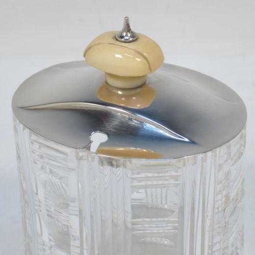 An elegant and stylish Art Deco Sterling Silver and hand-cut crystal jam, honey, or preserve jar, having a plain oval pull-off lid with matching bone finial and a slot for a spoon, and a hand-cut crystal body with reeded decoration and flat base. Made by Frank Cobb of Sheffield in 1936. The dimensions of this fine hand-made Art Deco silver and crystal jar are height 10 cms (4 inches), width 8 cms (3.25 inches), and depth 6.5 cms (2.5 inches)..  
