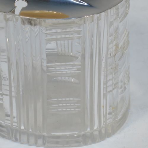 An elegant and stylish Art Deco Sterling Silver and hand-cut crystal jam, honey, or preserve jar, having a plain oval pull-off lid with matching bone finial and a slot for a spoon, and a hand-cut crystal body with reeded decoration and flat base. Made by Frank Cobb of Sheffield in 1936. The dimensions of this fine hand-made Art Deco silver and crystal jar are height 10 cms (4 inches), width 8 cms (3.25 inches), and depth 6.5 cms (2.5 inches)..  