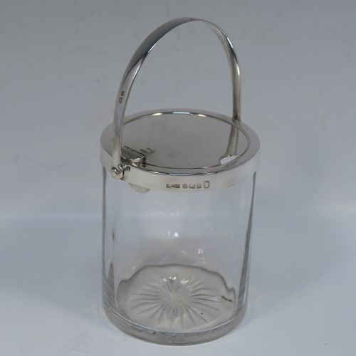A very elegant Art Deco Sterling Silver and crystal honey or jam jar, having a plain cylindrical and panelled body with star-cut base, a plain round mount, and a plain mechanical swing-handled hinged lid with cut-out for a honey or jam spoon (not included). This handsome silver honey or jam jar was made by Asprey of Birmingham in 1935. The dimensions of this fine hand-made silver and crystal conserve jar are height (inc. handle) 15 cms (6 inches), and diameter 8 cms (3 inches).   