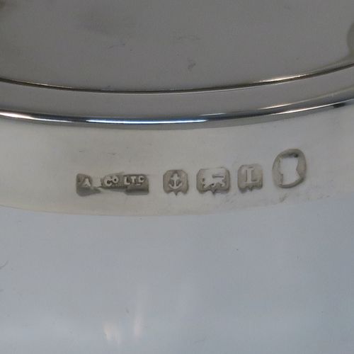 A very elegant Art Deco Sterling Silver and crystal honey or jam jar, having a plain cylindrical and panelled body with star-cut base, a plain round mount, and a plain mechanical swing-handled hinged lid with cut-out for a honey or jam spoon (not included). This handsome silver honey or jam jar was made by Asprey of Birmingham in 1935. The dimensions of this fine hand-made silver and crystal conserve jar are height (inc. handle) 15 cms (6 inches), and diameter 8 cms (3 inches).