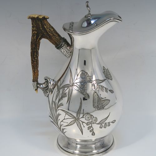 A beautiful and unusual Aesthetic style Antique Victorian Silver-Plated hot water or milk pot, having a round bellied body, with hand-chased butterfly and floral decoration, a horn antler handle, a hinged lid with a finial, and all sitting on a round pedestal foot. This beautiful antique Aesthetic silver plated hot milk or water pot was made by James Dixon and Sons of Sheffield in ca. 1880. The dimensions of this fine hand-made antique silver-plated serving pot are height 22 cms (8.75 inches), and length 14 cms (5.5 inches).   