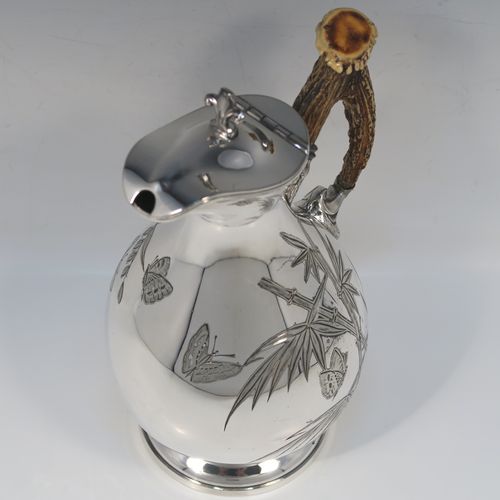 A beautiful and unusual Aesthetic style Antique Victorian Silver-Plated hot water or milk pot, having a round bellied body, with hand-chased butterfly and floral decoration, a horn antler handle, a hinged lid with a finial, and all sitting on a round pedestal foot. This beautiful antique Aesthetic silver plated hot milk or water pot was made by James Dixon and Sons of Sheffield in ca. 1880. The dimensions of this fine hand-made antique silver-plated serving pot are height 22 cms (8.75 inches), and length 14 cms (5.5 inches).   