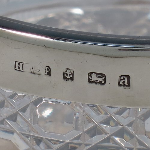An Antique Victorian Sterling Silver and hand-cut crystal ice bucket, having a round hob-nail cut crystal body sitting on four unusual conjoined legs, with an internal removable dry ice drainer, a plain silver rim, and a hinged swing handle. Made by the Henry Williamson Ltd., of Birmingham in 1900. The dimensions of this fine hand-made antique silver and crystal ice bucket are height (excluding handle) 12.5 cms (5 inches), and diameter at lip 12.5 cms (5 inches).
