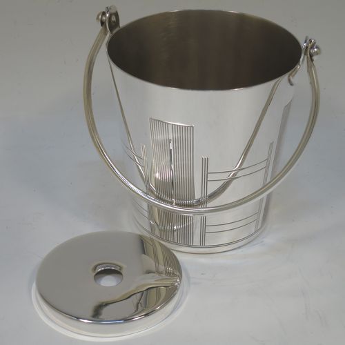 A very stylish Art Deco Silver Plated ice bucket, having a plain round body with tapering straight sides and hand-chased reeded decoration, an internal removable dry ice drainer, with a hinged loop handle, and all sitting on a flat base. Made in ca. 1930. The dimensions of this fine hand-made silver-plated ice bucket are height (not including handle) 11 cms (4.3 inches), and diameter at lip 11 cms (4.3 inches).