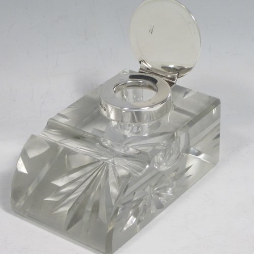 Antique Edwardian sterling silver and hand-cut crystal inkstand, having a rectangular body with chamfered corners, a pen holder groove above a curved front face, plain round silver mount with a hinged lid having an applied floral border, and all sitting on a star-cut flat base. Made by Broadway & Co., of Birmingham in 1904. The dimensions of this fine hand-made silver and crystal inkstand are height 5 cms (2 inches), length 10 cms (4 inches), and width 6.5 cms (2.5 inches).   