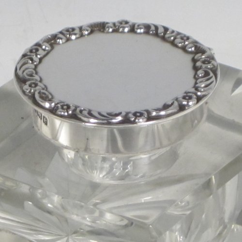 Antique Edwardian sterling silver and hand-cut crystal inkstand, having a rectangular body with chamfered corners, a pen holder groove above a curved front face, plain round silver mount with a hinged lid having an applied floral border, and all sitting on a star-cut flat base. Made by Broadway & Co., of Birmingham in 1904. The dimensions of this fine hand-made silver and crystal inkstand are height 5 cms (2 inches), length 10 cms (4 inches), and width 6.5 cms (2.5 inches).   